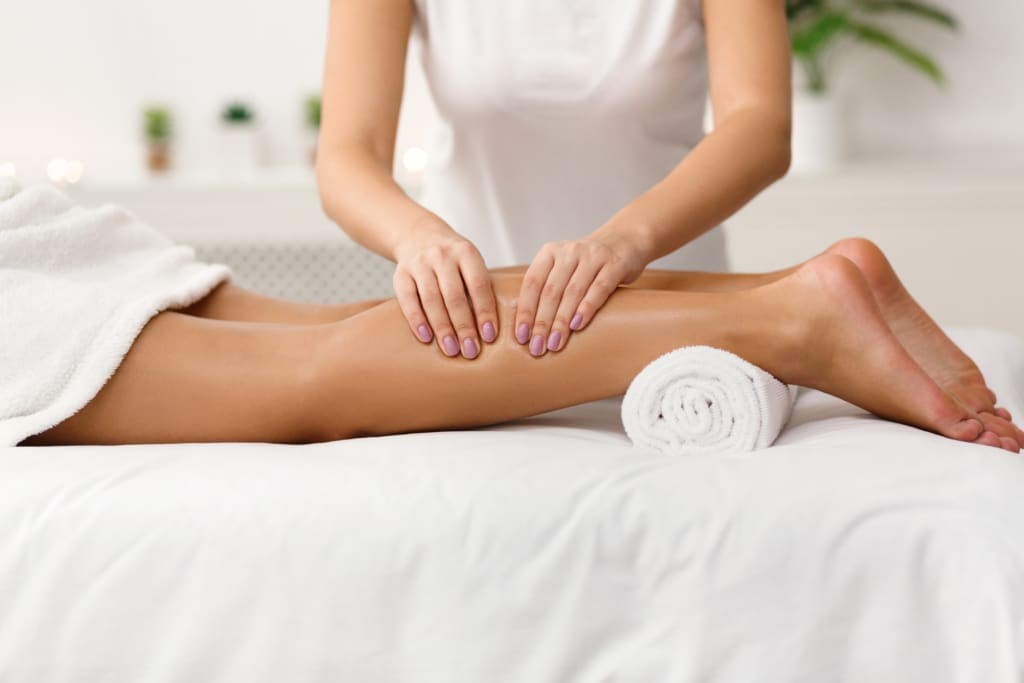 Alpenhaus Kaprun - Wellness, Sport, Erholung - Urlaub im Salzburger Land - Massage therapist massaging woman calves in spa center